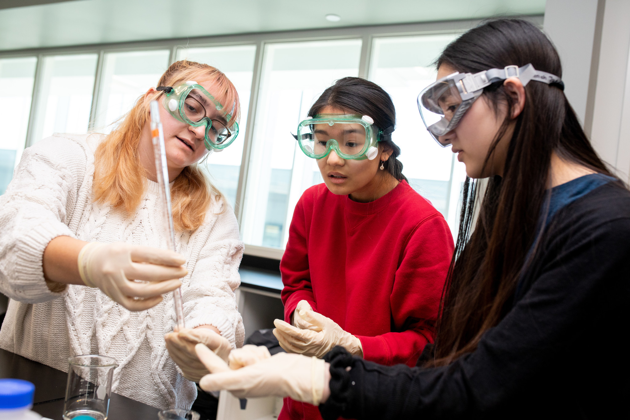 Three KU students work together in a chemistry lab.